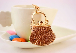 Close-up of a luxury handbag-shaped keychain with sparkling champagne rhinestones