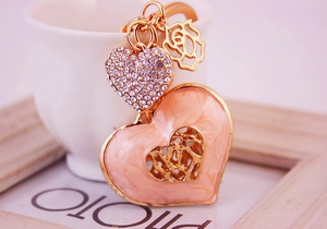 Detail of gold keychain with sparkling rhinestones and marble enamel hearts