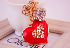 Detail of red enamel heart keychain with rhinestones and golden rose charm