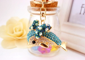 Detailed macro of a dolphin keychain with sparkling blue rhinestones and a gold bow ring
