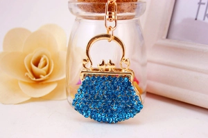 Detailed macro view of gold alloy handbag keychain featuring blue rhinestones and lobster clasp