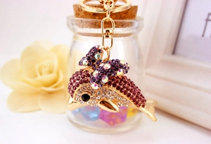 Close-up of golden dolphin keychain with purple rhinestones and lobster clasp
