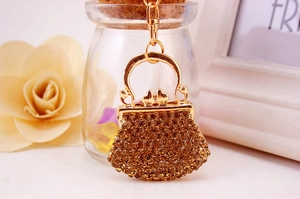 Macro shot of gold handbag keychain with amber rhinestones on a warm lifestyle background