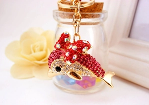 Detail of dolphin keychain with pink rhinestones and gold clasp in gift setting