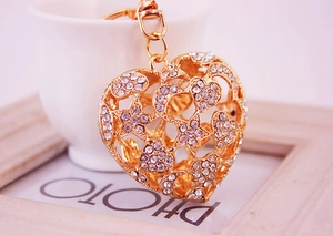 Détail d'un porte-clés coeur doré avec strass, motifs d'étoiles et lune évidés