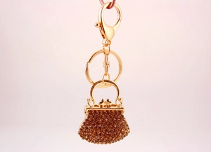 Detail of amber rhinestone-encrusted handbag charm with gold-tone lobster clasp