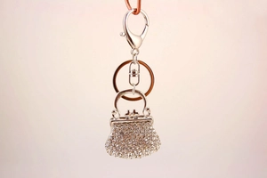 Detail of silver alloy handbag keychain with sparkling white rhinestones and lobster clasp
