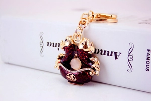 Detail of red enamel koi fish keychain with gold plating and lucky character engraving