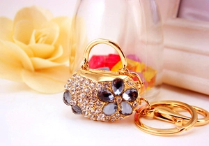 Macro shot of handbag-shaped metal keychain with white and grey crystal rhinestones