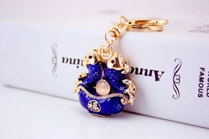 Macro shot of koi fish keychain with blue enamel, cat-eye stone, and Fu character