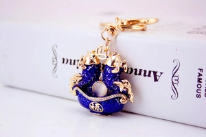 Macro detail of koi fish keychain with blue enamel and crystal-set Fu character charm