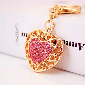 Golden heart keychain with sparkling pink rhinestones and a cutout metal frame design