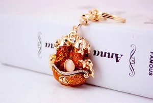 Detail of golden carp keychain with red enamel and diamond accents for luck