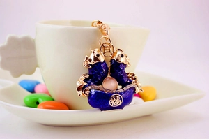 Close-up of golden koi fish keychain with blue enamel and lucky Fu character