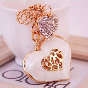 Elegant gold metal heart keychain with white enamel, rose charm, and sparkling rhinestones