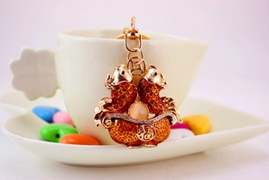 Detailed close-up of a golden carp koi keychain with red enamel and lucky Fu character