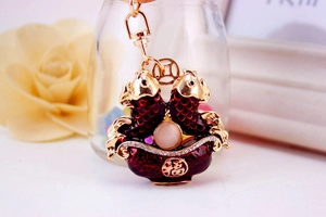 Detail view of double carp enamel keychain with gold finish and blessing charm