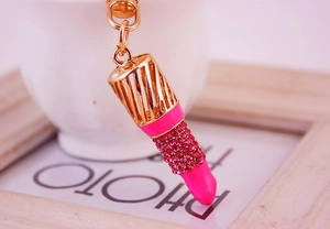 Détail d'un porte-clés rouge à lèvres aux strass roses avec crochet en métal doré brillant
