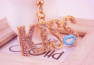 Macro shot of gold KISS keychain with clear rhinestones and a blue lip charm