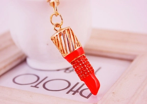 Vue détaillée du porte-clés rouge en forme de rouge à lèvres serti de strass brillants