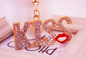 Macro detail of KISS letter keychain with white crystals and red lip charm
