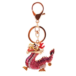 Golden dragon keychain with pink rhinestones and red enamel detailing on white background