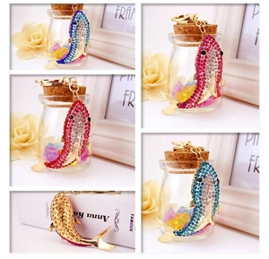 Detail of shark keychain with sparkling rhinestones in pink and blue on gold base