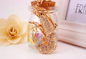 Close-up of a lobster keychain with gold plating and sparkling crystals on a gift background
