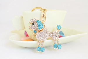 Détail du porte-clés caniche en cristal avec strass bleus suspendu à une tasse