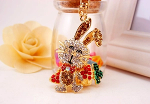 Détail du porte-clés lapin mignon en métal doré serti de strass et carotte