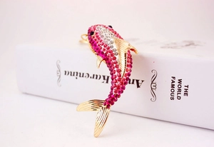 Detailed macro view of a pink gradient rhinestone shark pendant with gold-tone alloy
