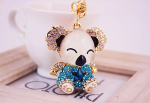Macro view of crystal koala keychain with blue star gemstone and gold metal links