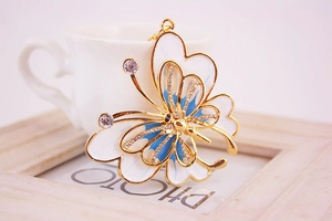 Detail of blue and white enamel butterfly keychain with sparkling rhinestones by a coffee cup