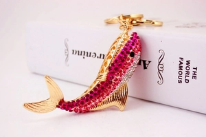 Close-up of pink and white crystal encrusted dolphin keychain with golden metal finish