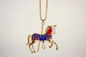 Detailed macro shot of a carousel horse pendant with blue rhinestones and enamel finish