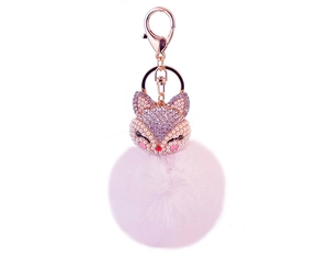 Close-up of fox keychain with pink faux fur pompom and sparkling crystal rhinestones