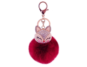 Detailed close-up of fox pendant with red faux fur pompom and sparkling crystal inlay