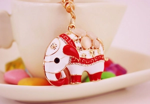Détail rapproché du porte-clés éléphant avec strass et émail blanc sur métal doré