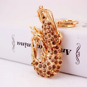 Golden lobster keychain with amber rhinestones and sparkling crystals on a book