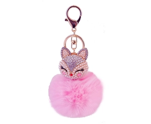 Macro detail of pink faux fur pompom and fox head pendant with pearls and rhinestones
