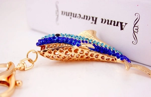 Close-up of golden shark keychain with blue rhinestones and heart hollow detail