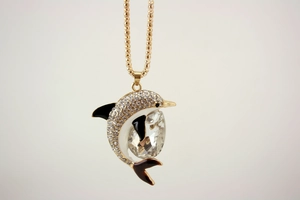 Detailed close-up of a golden dolphin pendant featuring crystals and enamel accents