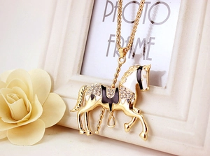 Macro shot of carousel pendant with enamel details and sparkling rhinestones on gold chain