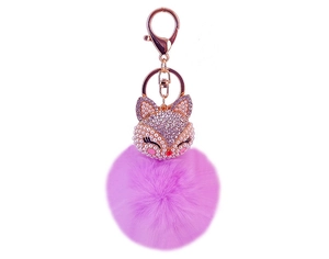 Dettaglio portachiavi a pompon viola con testa di volpe in cristallo e metallo oro