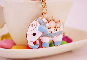 Vue macro d'un porte-clés éléphant en émail blanc avec pierres roses sur une base métallique