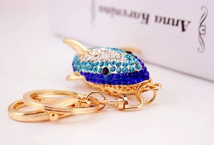 Macro view of blue crystal shark keychain with sparkling rhinestones and golden hardware