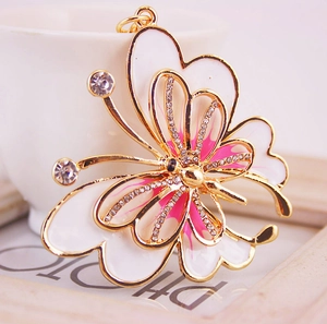 Exquisite golden butterfly keychain with pink and white enamel wings and sparkling rhinestones