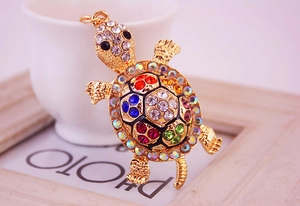 Détail macro du porte-clés tortue dorée avec des strass multicolores incrustés