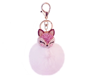 Macro detail of fox keychain with pink rhinestones, faux pearls and soft pompom