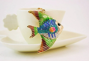 Gros plan d'un porte-clés poisson tropical avec strass bleus et émail coloré sur tasse